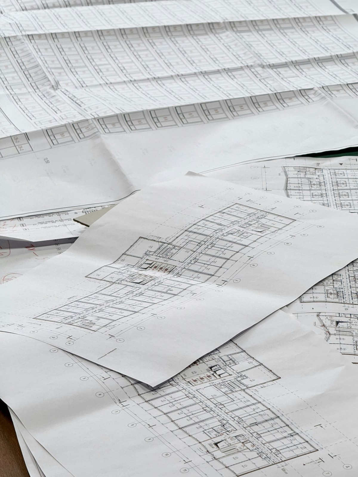 Architectural blueprints and construction drawings spread across a table