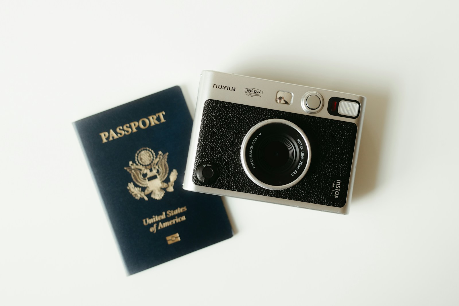 A U.S. passport resting on a table with a camera, ready for travel